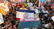 Rui Costa segura bandeira de torcida do Bahia durante caminhada com Lula em Salvador