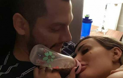 Andressa Urach aparece tomando mamadeira no colo do marido