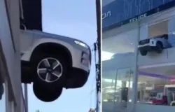 Carro cai de vitrine e fica pendurado no segundo andar de loja de carros em Porto Alegre