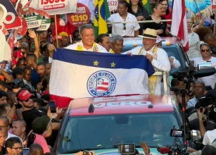Rui Costa segura bandeira de torcida do Bahia durante caminhada com Lula em Salvador