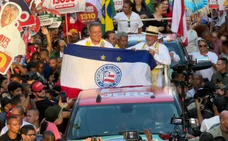 Rui Costa segura bandeira de torcida do Bahia durante caminhada com Lula em Salvador