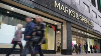 Uma fachada da loja Marks and Spencer com compradores passando