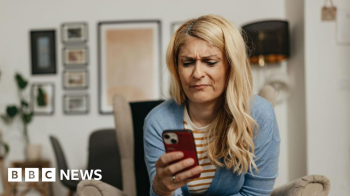 Getty Images Blonde woman looks frustrated while using her smartphone at home
