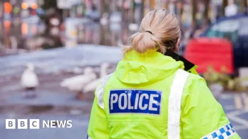 Getty Images Um policial de jaqueta amarela brilhante com a palavra pol�cia escrita nas costas.