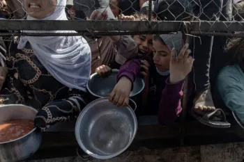 Palestinos deslocados internamente aguardam do lado de fora de uma cozinha comunit�ria para receber por��es limitadas de alimento, em meio � escassez de comida, em Khan Younis, sul da Faixa de Gaza,