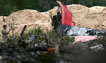 Um policial monta guarda perto dos destro�os do voo 171 da Air India ap�s a queda em uma �rea residencial