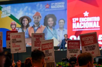 Militante petista levanta placa pedindo "reciprocidade na taxa��o de Trump" durante o 17� Encontro Nacional do partido, em Bras�lia