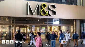 Getty Images Uma multid�o de pessoas caminha do lado de fora de uma grande loja M&S com uma placa da M&S pendurada acima
