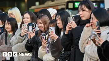 Grupo de mulheres japonesas segurando seus telefones para gravar e tirar fotos de uma cena em frente a elas
