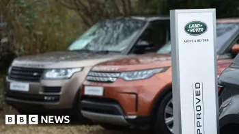 AFP via Getty Images Dois Range Rovers estacionados ao lado de uma placa que diz Land Rover