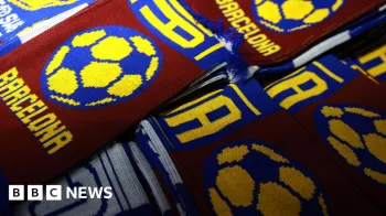 Len�os vinho e azul do FC Barcelona sobrepostos em cima de uma mesa em uma barraca do lado de fora de um est�dio.
