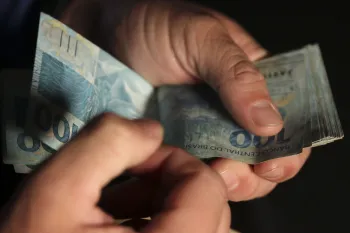Homem mexendo em notas de cem reais �? Jos� Cruz/Ag�ncia Brasil