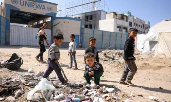 Crian�as brincam perto do lixo em frente � sede fechada da ag�ncia da ONU para refugiados palestinos (UNRWA), na Cidade de Gaza