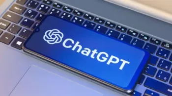 Getty Images Um teclado de laptop com um celular em cima. Na tela do telefone est� o logotipo azul e branco do ChatGPT.