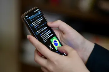 (ARQUIVOS) Um usu�rio brasileiro da rede social X, anteriormente Twitter, navega por postagens em um celular em Bras�lia em 31 de agosto de 2024