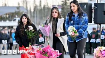 Reuters Tr�s mulheres colocam flores em um memorial improvisado nos degraus da prefeitura em Tumbler Ridge.