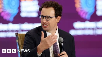 Reuters Dario Amodei, CEO da Anthropic, falando em nome da empresa enquanto segura um microfone, usando um palet� preto, camisa branca e gravata vermelha e azul marinho.