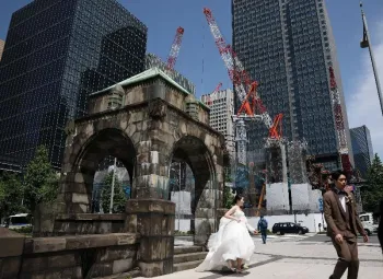 Casal tira fotos de seu casamento perto de um canteiro de obras em T�quio 19 de maio de 2026. REUTERS/Issei Kato