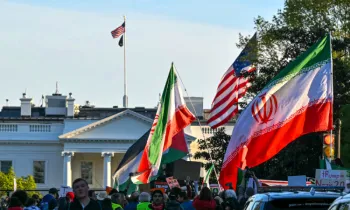 Manifestantes agitam bandeiras iranianas durante um protesto contra a a��o militar dos EUA no Ir�, perto da Casa Branca, em Washington