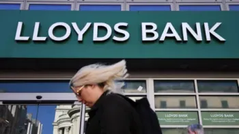 EPA/Shutterstock O logotipo do Lloyds Bank na fachada de uma ag�ncia banc�ria. Na frente, uma mulher de cabelos loiros passa