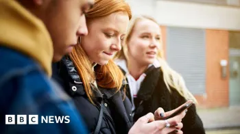 Tr�s adolescentes do lado de fora olhando para um telefone