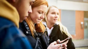 Tr�s adolescentes olhando para um celular