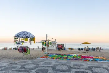 Sem serem coibidos, camel�s exp�em cangas na areia e biqu�nis em guarda-s�is na orla de Ipanema. Foto: Guito Moreto