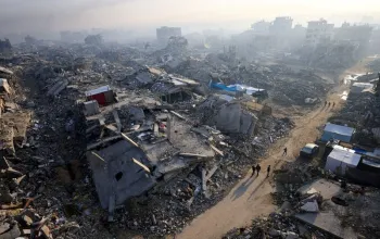 Palestinos caminham entre os escombros de pr�dios destru�dos na cidade de Gaza. Foto: Reuters/Dawoud Abu Alkas