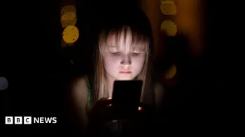 Uma crian�a olhando para o celular