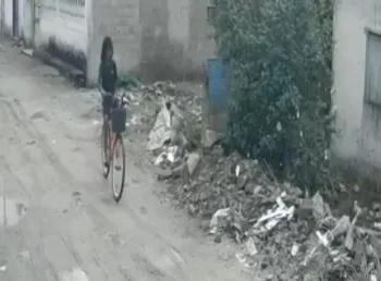 Imagens de c�mera de seguran�a mostram o momento em que o adolescente passa de bicicleta