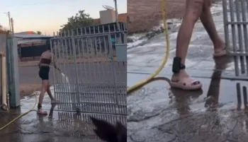 Imagem do v�deo que mostra Gleyci Alencar lavando a cal�ada com um p� dentro de casa.