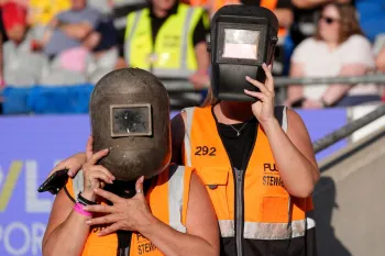Stewards usando capacetes de solda para assistir ao eclipse solar (Imagem: Niall Carson/PA Wire)