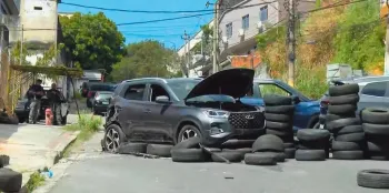 A barricada com pneus e tr�s ve�culos onde foram encontrados explosivos, que podiam ser acionados � dist�ncia, na Cidade Alta. Foto: Reprodu��o/TV Globo