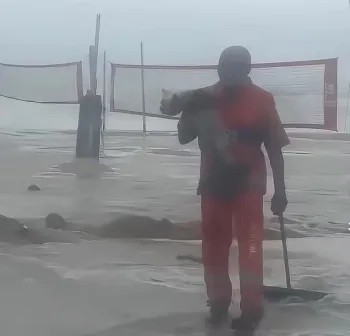 Gari Jo�o Batista Paulino Tavares resgata cachorro levado pela correnteza durante a ressaca em Copacabana, na Zona Sul do Rio Foto: Reprodu��o/Comlurb