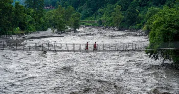 Pessoas caminham sobre uma ponte suspensa para atravessar o rio Trishuli, que est� inundado, em Bhaise, Nuwakot, Nepal, em 8 de julho de 2025. Ambir Tolang/NurPhoto/Getty Images via CNN Newsource