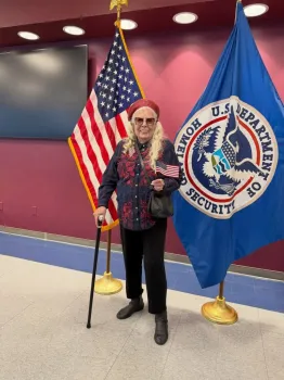 Joni Mitchell segura uma bandeira dos EUA durante a cerim�nia de naturaliza��o. Foto: Joni Mitchell / Instagram