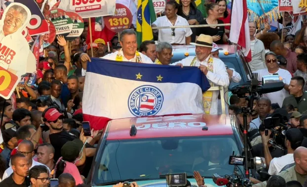 Rui Costa segura bandeira de torcida do Bahia durante caminhada com Lula em Salvador