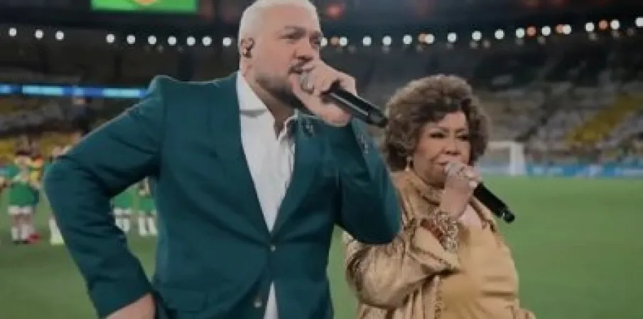 Belo e Alcione s�o criticados ap�s cantar o hino nacional em jogo